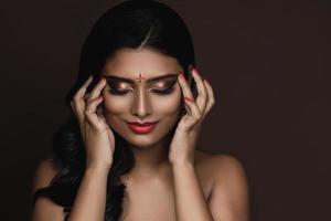 portret van Indisch vrouw met mooi bedenken en kapsel Aan bruin achtergrond foto
