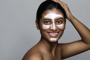 jong Indisch vrouw met een reiniging masker toegepast Aan haar gezicht foto