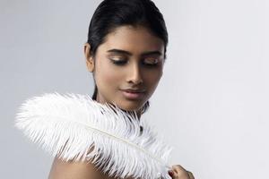 jong en sensueel Indisch vrouw met een zacht struisvogel veer foto