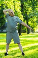 ouderen Mens oefenen in groen stad park gedurende zijn geschiktheid training foto