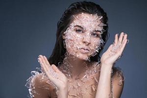 vrouw gezicht gedekt met een veel klein stukken van glas of ijs foto