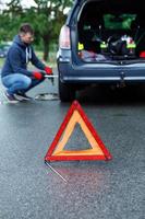 waarschuwing driehoek en Mens veranderen auto wiel foto