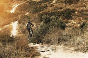 mtb fiets rijder jumping gedurende bergafwaarts rijden Aan zijn fiets in bergen foto