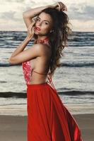 verbijsterend vrouw vervelend mooi rood jurk Aan de strand foto