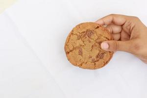 overhead visie van Holding chocola zoet koekjes Aan wit achtergrond foto