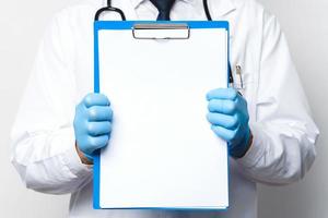 dokter is Holding een klembord met een blanco wit papier foto