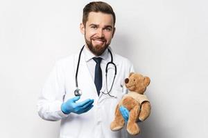 professioneel kinderarts met een teddy beer in zijn handen foto