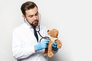 professioneel kinderarts met een teddy beer in zijn handen foto