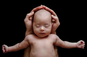 schattig pasgeboren baby aan het liegen in de vader handen foto