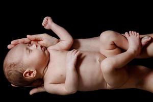 schattig pasgeboren baby aan het liegen in de moeder handen foto