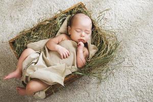 schattig baby slapen in de doos gevulde met een hooi foto