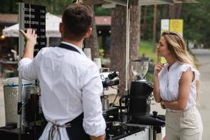 barista Mens aanbod naar Kiezen divers soorten van koffie naar de vrouw klant foto