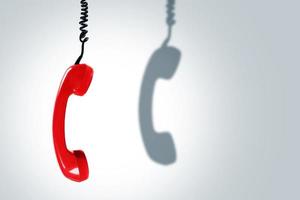 rood telefoon handset met een donker schaduw. concepten van hotline, ondersteuning of telefoon oplichting. foto