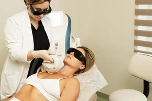 vrouw cliënt gedurende ipl behandeling in een schoonheidsspecialiste kliniek foto