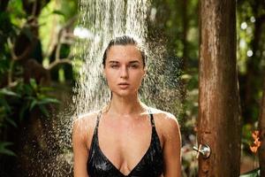 mooi vrouw nemen buitenshuis douche in de tropisch oerwoud foto