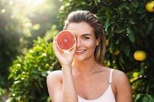 mooi vrouw met glad huid met een grapefruit in haar handen foto