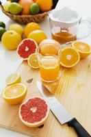 gesneden citrus fruit en glas van vers oranje sap Aan de snijdend bord foto