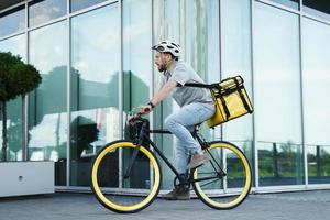 uitdrukken levering koerier rijden fiets met geïsoleerd tas. foto