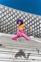 zorgeloos vrouw vervelend kleurrijk sportkleding jumping Aan de straat gedurende zomer dag foto