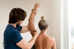 professioneel masseur gebruik makend van acupressuur technieken voor van de klant gewond arm foto