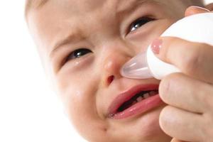 moeder gebruik makend van nasaal aspirator Aan haar kind neus. foto