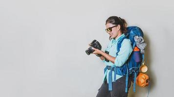 concept beeld van een meisje met een rugzak in een handheld camera Aan een wit achtergrond. reizen rugzak. reizen in de omgeving van de wereld. foto