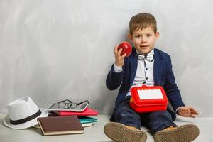 schattig schooljongen aan het eten buitenshuis de school- van plastic lunch doos. gezond school- ontbijt voor kind. voedsel voor lunch, lunch trommel met boterhammen, fruit, groenten, en water foto