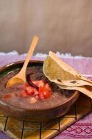 bonen gekookt in een klei schotel met tomaat en tortilla's, Mexicaans arm schotel foto