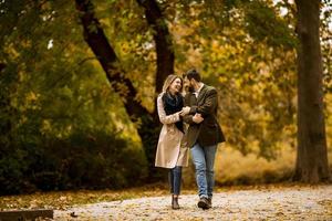 jong stel wandelen in het herfstpark foto