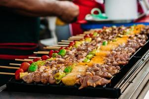 een populair barbecue met varkensvlees filet, tomaat, naar smaak en rooster , barbeque Aan heet rooster foto