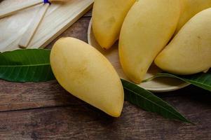 zoet geel mango fruit Aan hout tafel , klaar naar eten voor gezond , fruit Aan zomer foto