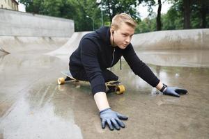 jong gehandicapten vent met een longboard in een skatepark foto