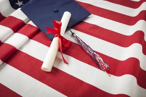 diploma uitreiking pet en diploma resting Aan Amerikaans vlag foto