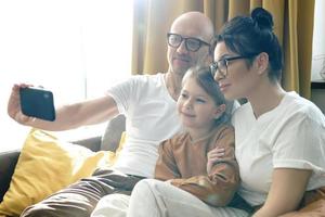 gelukkig familie nemen selfie gebruik makend van smartphone Bij huis foto