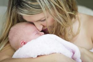 jong mooi moeder Holding haar kostbaar pasgeboren baby meisje foto