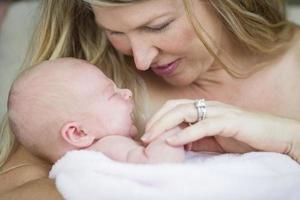 jong mooi moeder Holding haar kostbaar pasgeboren baby meisje foto