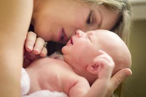 jong mooi moeder Holding haar kostbaar pasgeboren baby meisje foto