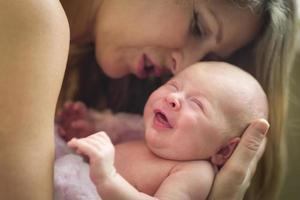 jong mooi moeder Holding haar kostbaar pasgeboren baby meisje foto