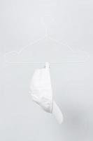 wit basketbal pet hangende Aan een hanger tegen grijs achtergrond foto
