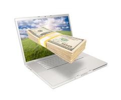 laptop met stack van geld komt eraan van scherm foto