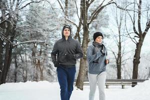 sportief paar gedurende winter jogging in stad park foto