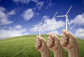 mannetje vuisten Holding drie wind turbines buiten foto