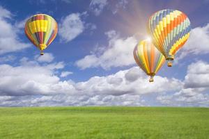 heet lucht ballonnen in mooi blauw lucht bovenstaand gras veld- foto