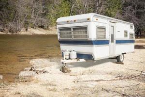klassiek oud camper aanhangwagen in de buurt een rivier- foto