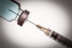 medisch injectiespuit naald- en vaccin flacon tegen wit achtergrond foto