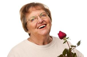 aantrekkelijk senior vrouw met rood roos foto