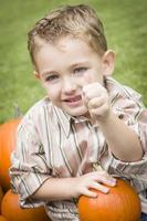 schattig jong kind jongen genieten van de pompoen patch. foto