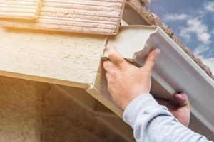 arbeider Vastmaken aluminium regen goot naar bindweefsel van huis. foto