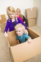 jong familie in leeg kamer spelen met in beweging dozen foto