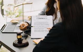 mannelijke advocaat die met contractdocumenten en houten hamer op tafel in rechtszaal werkt. justitie en recht, advocaat, rechter, concept. foto